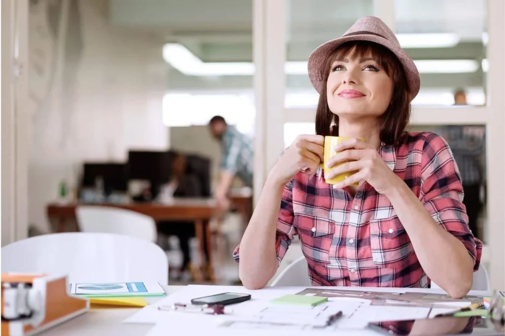 Peer Sales Agency hiring manager holding coffee and looking contently at the current team.