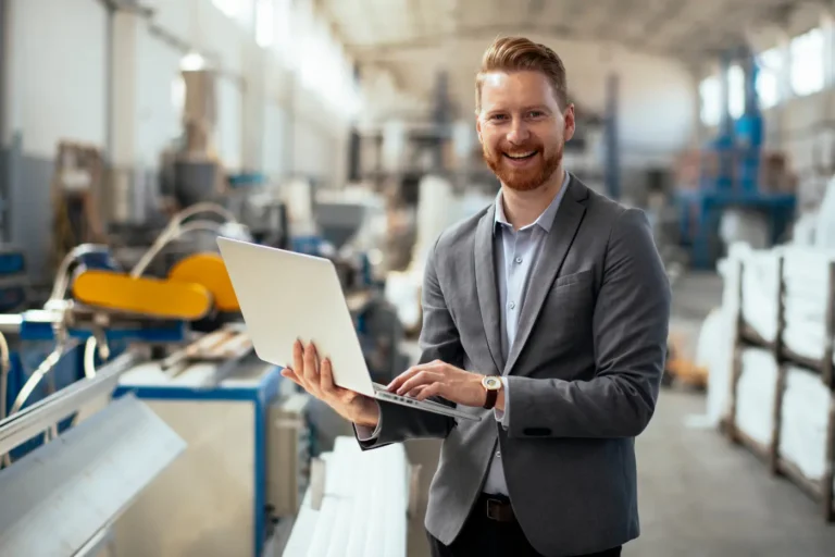 Manufacturing CEO with laptop exploring outsourced marketing for his company.