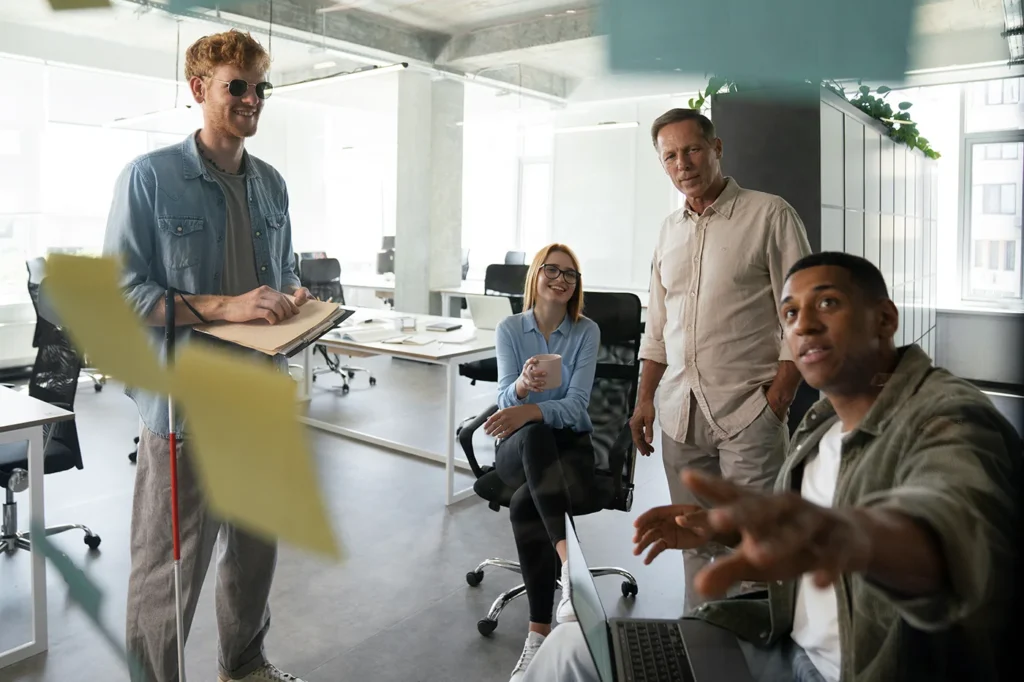 Team collaborating in a modern office with sticky notes on a glass board, illustrating strategy planning for a Nebraska HubSpot implementation.