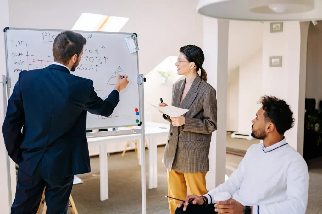 A mid-market professional services team diagrams part of their sales engine on an office whiteboard.